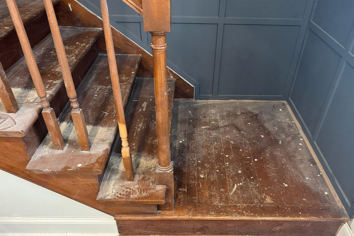 Wooden stairs and railing restored after laser cleaning, showing a clean, smooth surface with natural wood grain revealed.