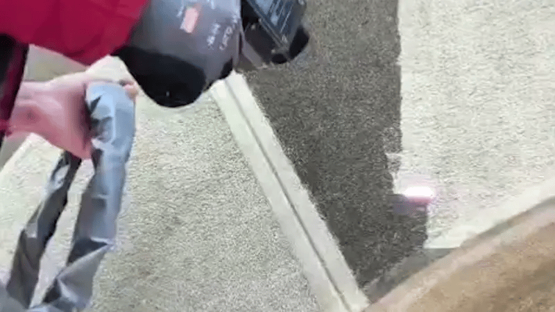 Laser graffiti cleaning machine removing coating from concrete wall, showing a clear contrast between cleaned and uncleaned areas.