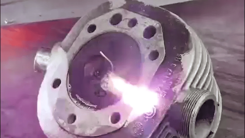 Laser cleaning process removing oil and grime from an industrial metal component with precise, contact-free laser beams.