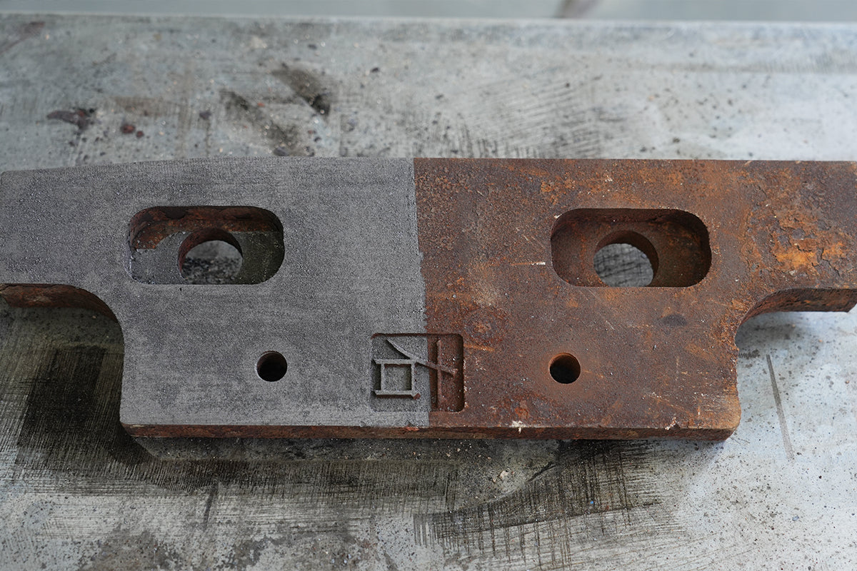 Laser cleaning removes rust from a steel mechanical part, showing a clear before-and-after comparison on the same workpiece.