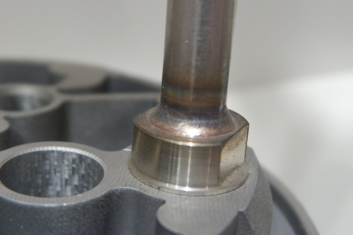 Laser-welded metal joint showing a clean, precise weld between a tube and a machined metal component.