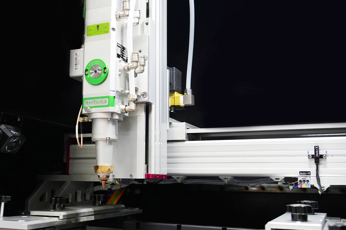 Close-up of an advanced fiber laser cutting head operating on a metal platform, designed for high-precision industrial cutting.