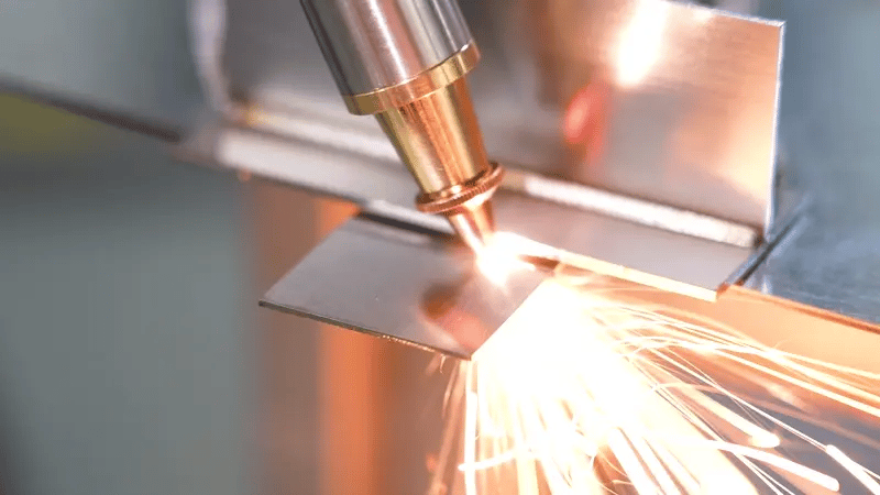 Fiber laser surface cleaning and restoration removing rust and contaminants from a metal plate with bright sparks.