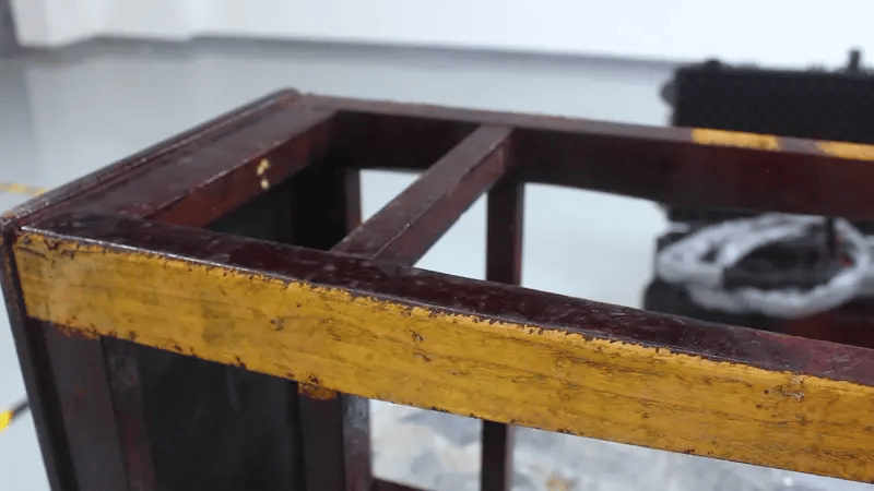 Laser cleaning machine removing paint and contaminants from wooden surface without damaging the material.