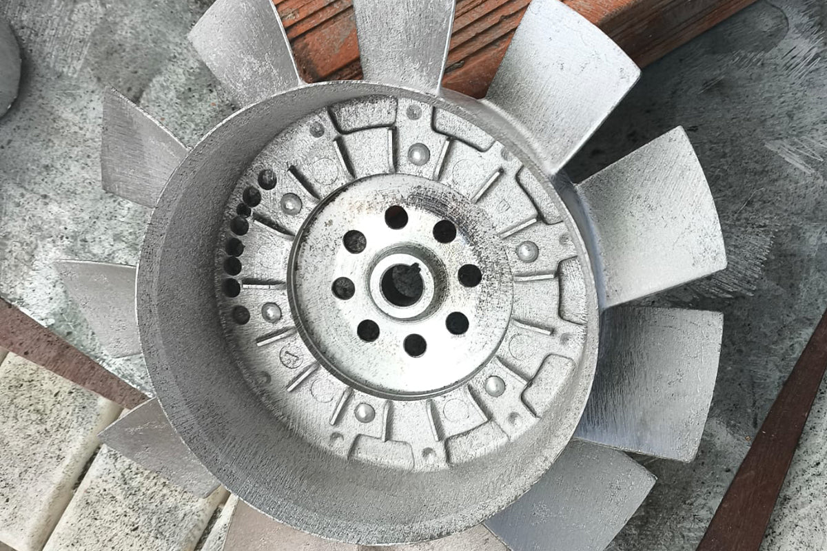 Dirty metal component covered with oil residue before laser degreasing comparison.